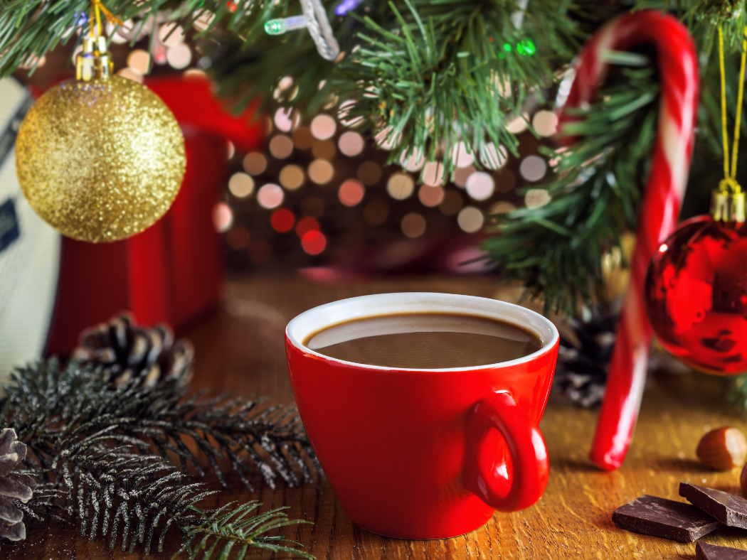 Une tasse sous un sapin avec un sucre d'orge et pommes de pin